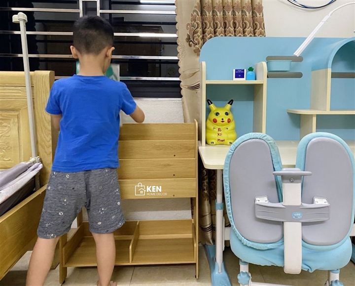 Bé đứng trước kệ, tự chọn đồ, chụp từ sau lưng